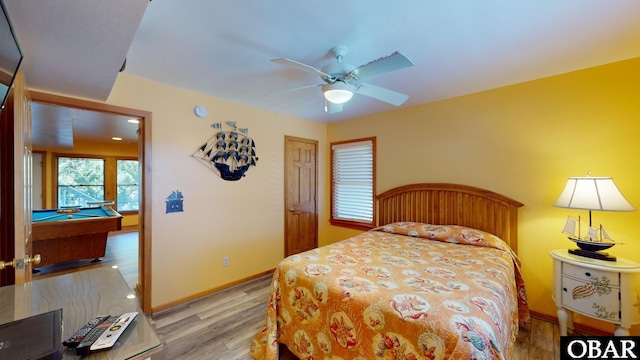 bedroom featuring light wood finished floors, ceiling fan, pool table, and baseboards