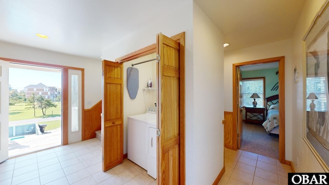 clothes washing area with wainscoting, laundry area, independent washer and dryer, and light tile patterned flooring