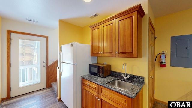 kitchen with a sink, visible vents, electric panel, and black microwave