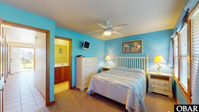 tiled bedroom with a sink, ensuite bath, and a ceiling fan