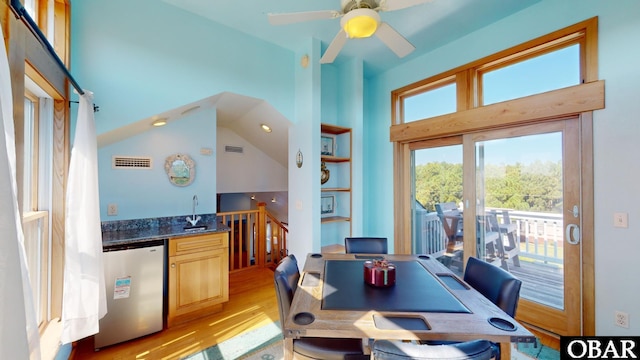 dining space featuring wet bar, light wood-style floors, visible vents, and ceiling fan