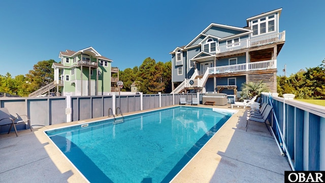 view of pool with a patio area, a fenced in pool, a hot tub, and stairs