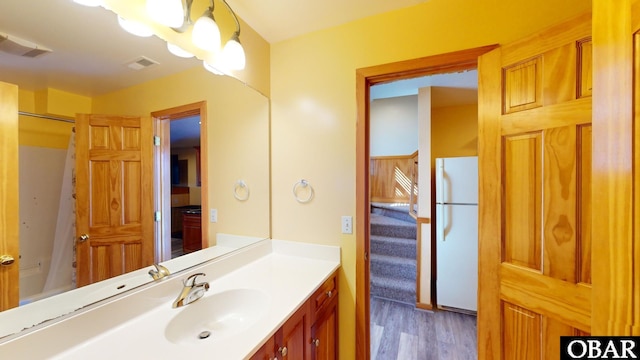 bathroom with visible vents, vanity, a shower with curtain, and wood finished floors