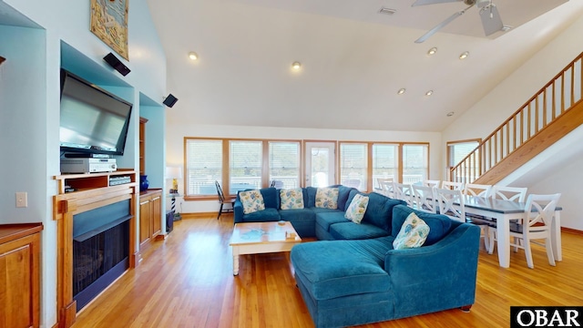 living room with a fireplace, a wealth of natural light, and high vaulted ceiling