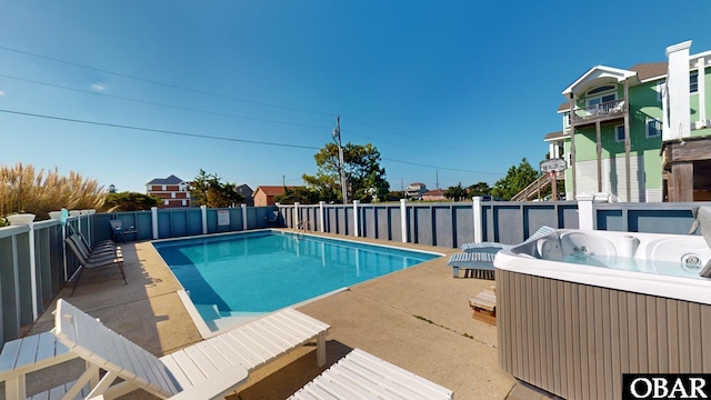 view of swimming pool featuring a patio, a fenced in pool, and a hot tub