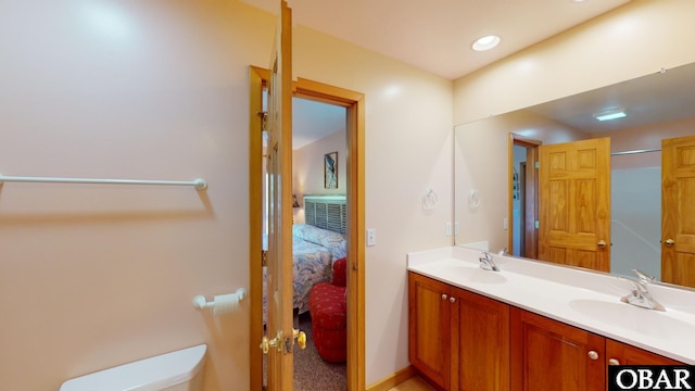 bathroom featuring double vanity, toilet, ensuite bathroom, and a sink