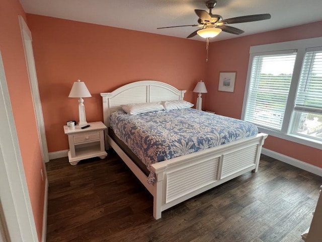 bedroom with dark wood-style floors, ceiling fan, and baseboards