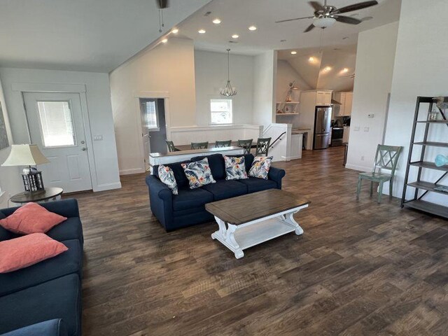 living area featuring dark wood-style floors, high vaulted ceiling, ceiling fan with notable chandelier, and recessed lighting