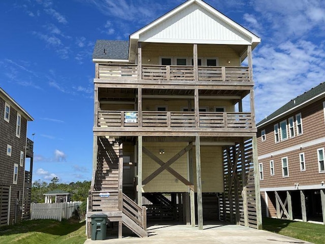 view of front of house featuring a balcony, stairway, board and batten siding, and concrete driveway