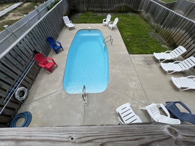 view of swimming pool with a fenced in pool, a fenced backyard, and a patio