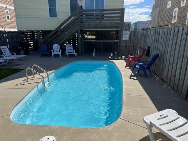 pool with a patio area and a fenced backyard