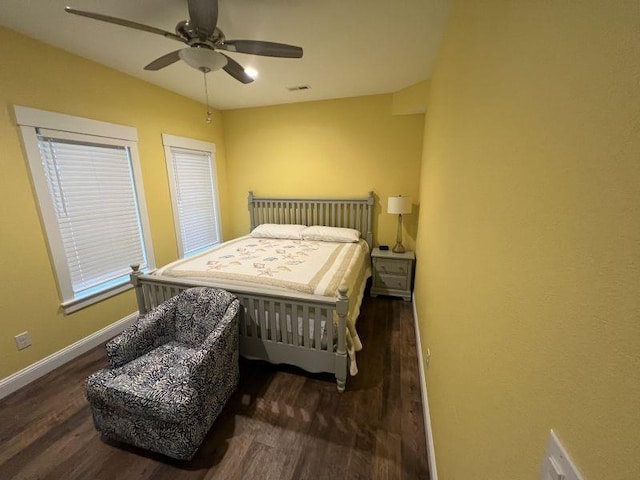 bedroom featuring a ceiling fan, visible vents, baseboards, and wood finished floors