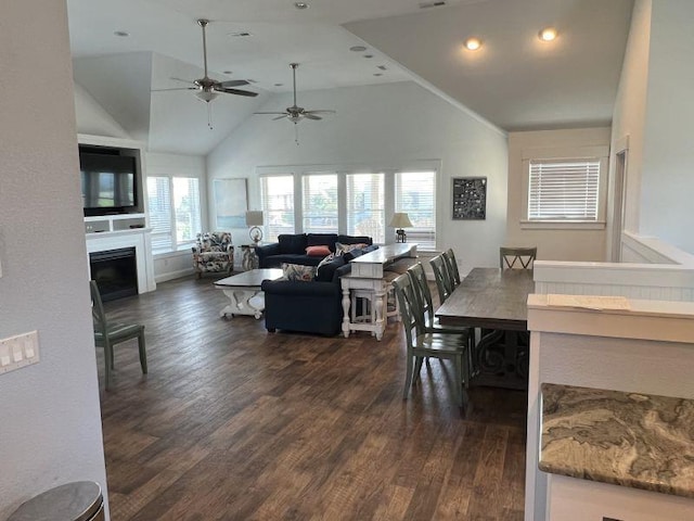 dining space with high vaulted ceiling, dark wood-type flooring, a fireplace, and recessed lighting