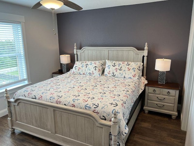 bedroom with dark wood-style floors, ceiling fan, and multiple windows