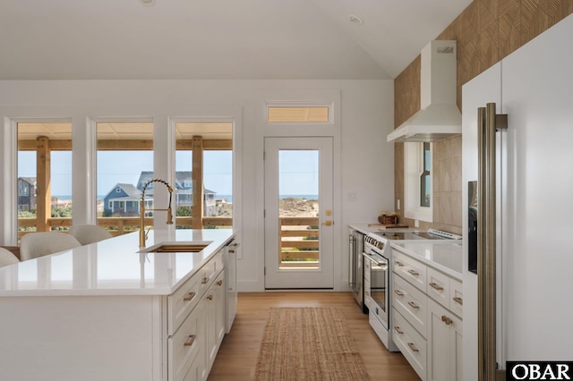 2072 Sandfiddler Rd Lot 85, Corolla, NC 27927 - kitchen with wall chimney exhaust hood, white appliances, a sink, light countertops, and light wood-style flooring