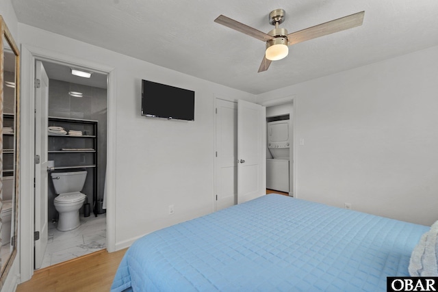 40048 Marlin Dr Lot 152, Avon, NC 27915 - bedroom featuring stacked washer and clothes dryer, light marble finish flooring, ensuite bathroom, and a ceiling fan