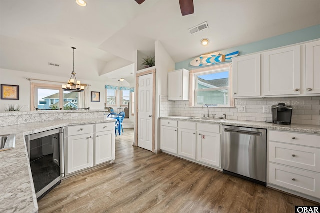 kitchen with pendant lighting, white cabinets, a sink, and stainless steel dishwasher