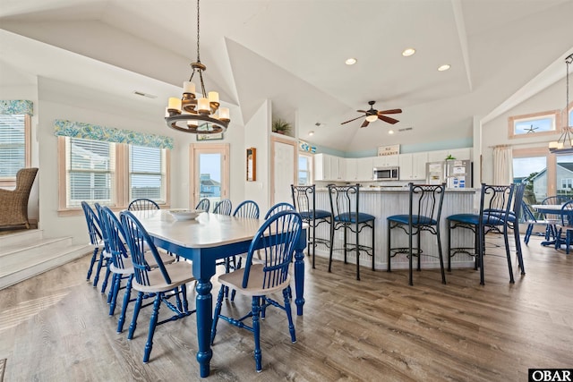 dining room with high vaulted ceiling, wood finished floors, visible vents, and a healthy amount of sunlight