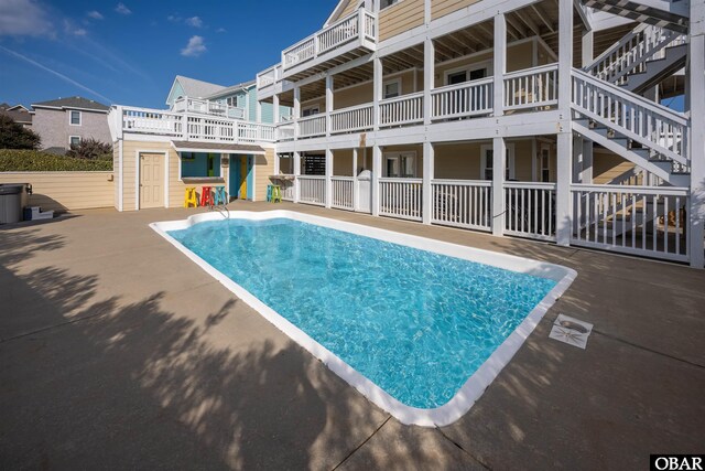 view of pool with a fenced in pool, a patio, stairway, and fence