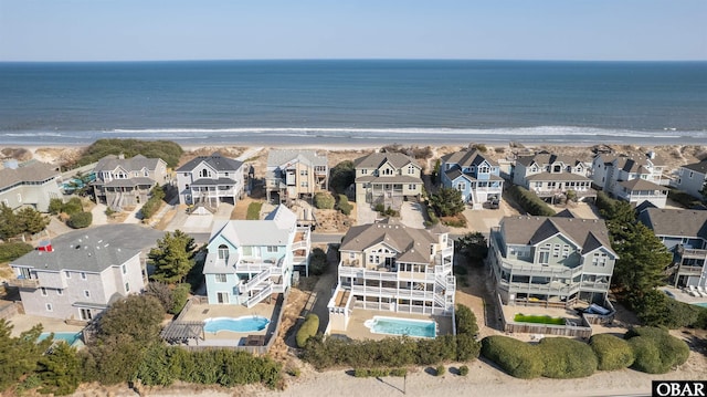 aerial view featuring a water view, a view of the beach, and a residential view