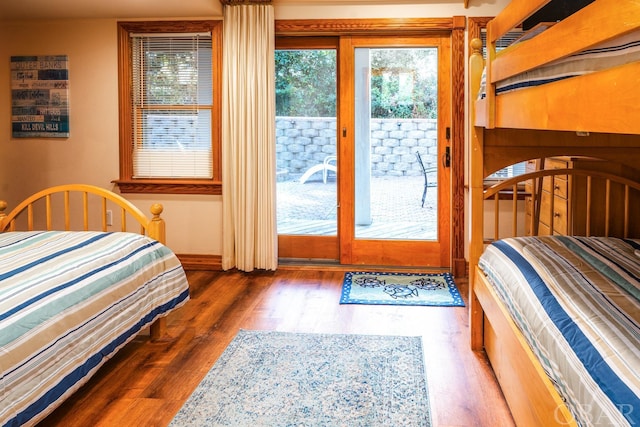 bedroom with access to outside, baseboards, and dark wood finished floors