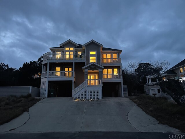 view of front facade featuring stairs, driveway, a balcony, and a garage