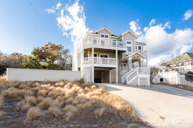 view of front of property featuring stairway and concrete driveway