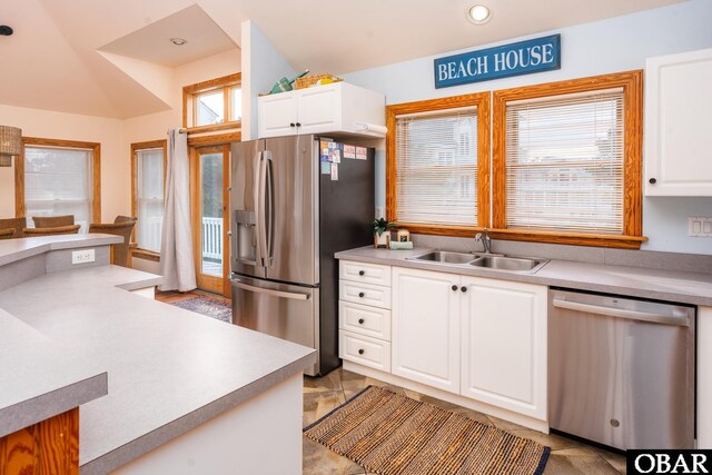 kitchen featuring white cabinetry, appliances with stainless steel finishes, light countertops, and a sink