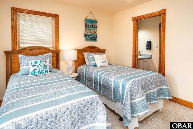 bedroom with baseboards, carpet flooring, and ensuite bathroom