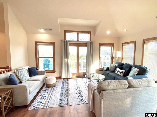 living area featuring visible vents and wood finished floors