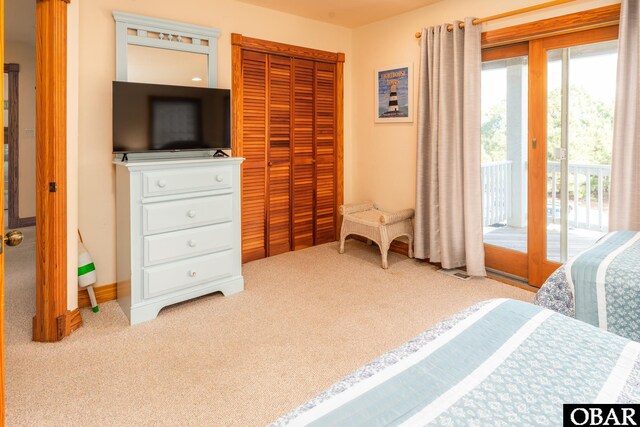 bedroom with access to exterior, a closet, and light colored carpet