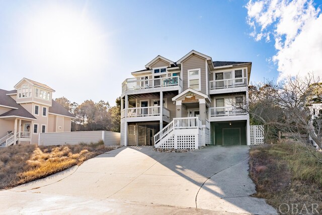 view of front of house featuring an attached garage, stairway, and concrete driveway