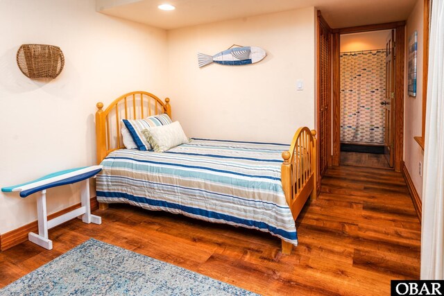 bedroom with dark wood-style floors and baseboards