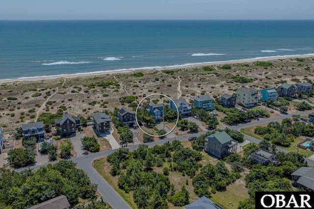 drone / aerial view featuring a water view and a beach view