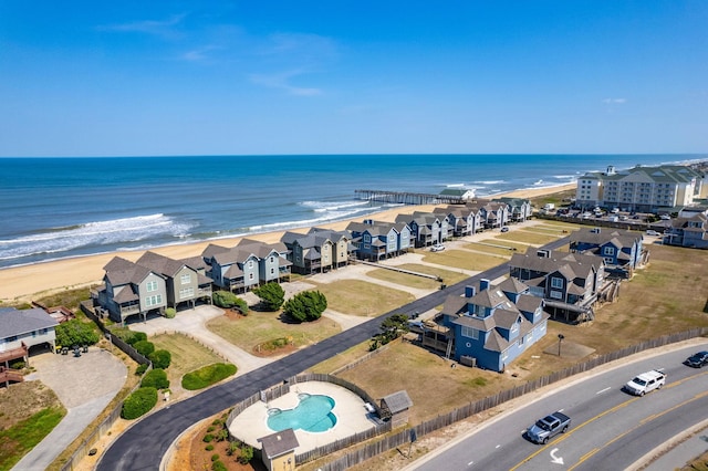 drone / aerial view featuring a water view, a residential view, and a view of the beach