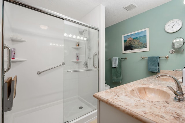 full bathroom with toilet, a shower stall, visible vents, and a sink