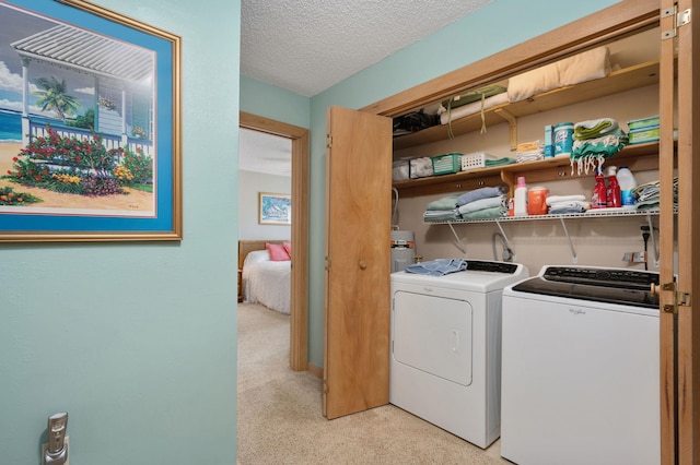 laundry room featuring laundry area, washing machine and dryer, water heater, and a textured ceiling