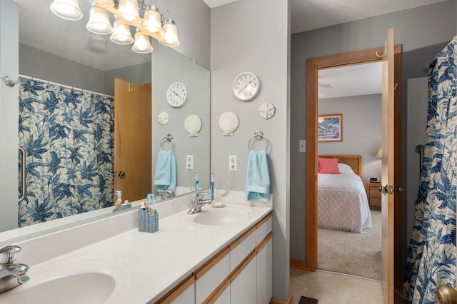 ensuite bathroom with a textured ceiling, a chandelier, a sink, and ensuite bathroom