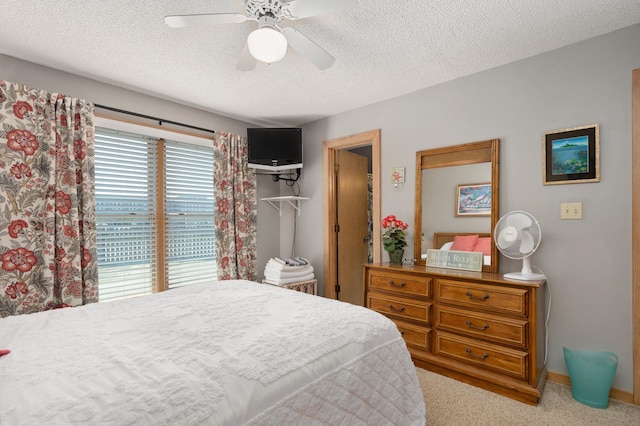 bedroom with baseboards, carpet, a ceiling fan, and a textured ceiling