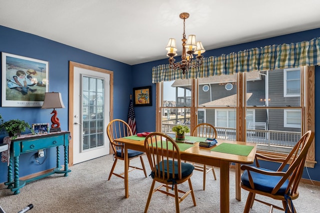 dining area with carpet flooring and an inviting chandelier