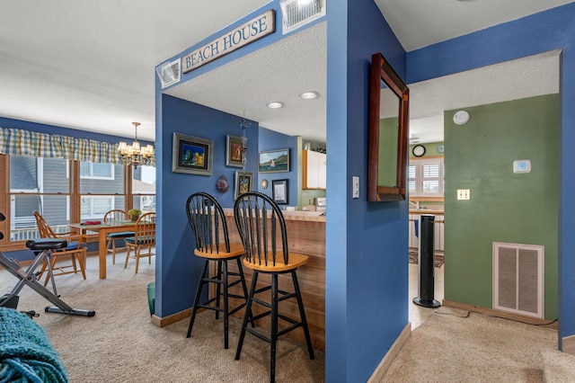 interior space with baseboards, visible vents, a notable chandelier, and light colored carpet