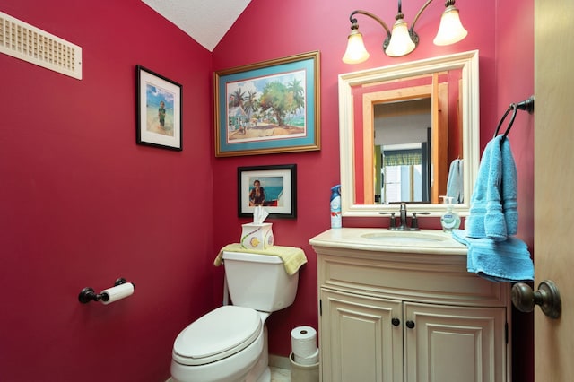 bathroom featuring lofted ceiling, vanity, and toilet