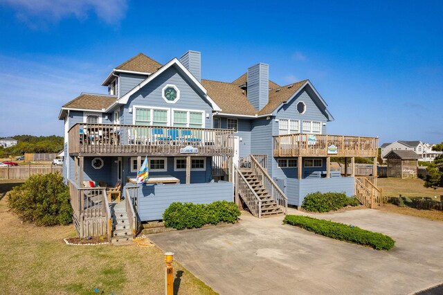 back of house featuring stairs, a deck, and a chimney