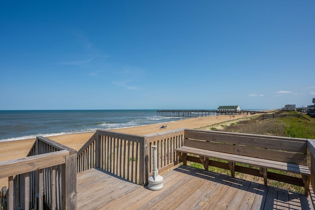 wooden deck with a water view and a beach view