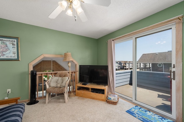 carpeted living room featuring a ceiling fan and a textured ceiling