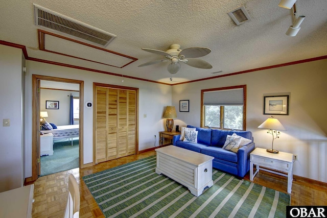 50050 Bayside Ct Lot 30, Frisco, NC 27936 - living room featuring attic access, ceiling fan, crown molding, baseboards, and a textured ceiling