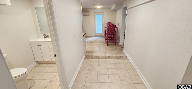4327 S Hammerhead Dr Lot # 37, Nags Head, NC 27959 - corridor featuring light tile patterned floors, a sink, a wall unit AC, and baseboards