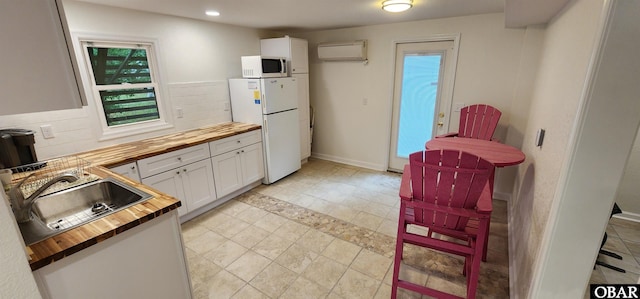 4327 S Hammerhead Dr Lot # 37, Nags Head, NC 27959 - kitchen featuring butcher block countertops, white appliances, a sink, an AC wall unit, and white cabinetry