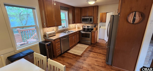 4327 S Hammerhead Dr Lot # 37, Nags Head, NC 27959 - kitchen with stainless steel appliances, a sink, washer / dryer, dark wood-style flooring, and tasteful backsplash