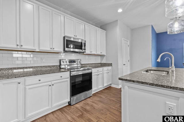 115 Sligo Way Lot 10, Moyock, NC 27958 - kitchen featuring stainless steel appliances, wood finished floors, white cabinets, tasteful backsplash, and recessed lighting